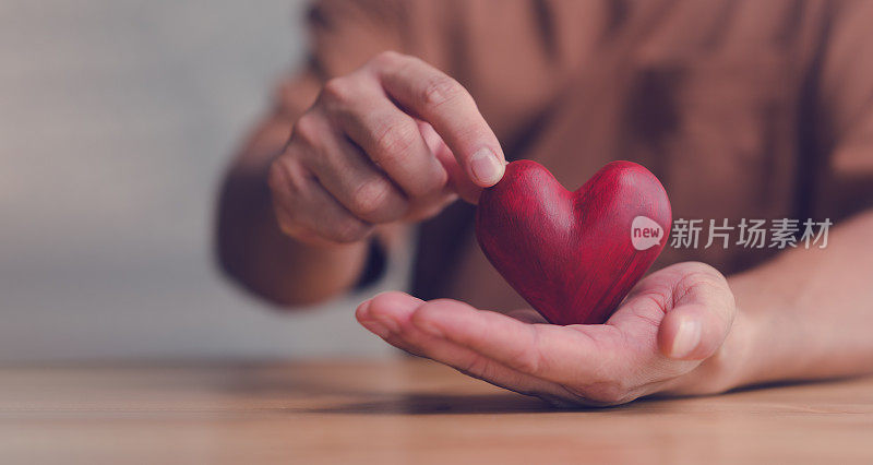 Male hands holding red heart, world mental health day and world heart day, Life and health insurance, CSR social responsibility, organ donation, ​concept of love